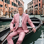 Mann im rosa Anzug sitzt entspannt in einer Gondel auf einem Kanal in Venedig, symbolisiert internationalen Stil und Wirtschaft im Wandel